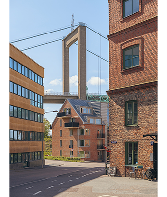 Hasselblad X1D Sample Image of red brick buildings in the foreground with a brutalist concrete highway bridge in the background with a clear blue sky